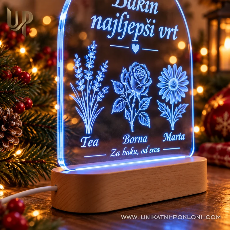 Detalj plavo osvijetljene gravure cvijeća i imena Tea, Borna i Marta na akrilnoj lampi.